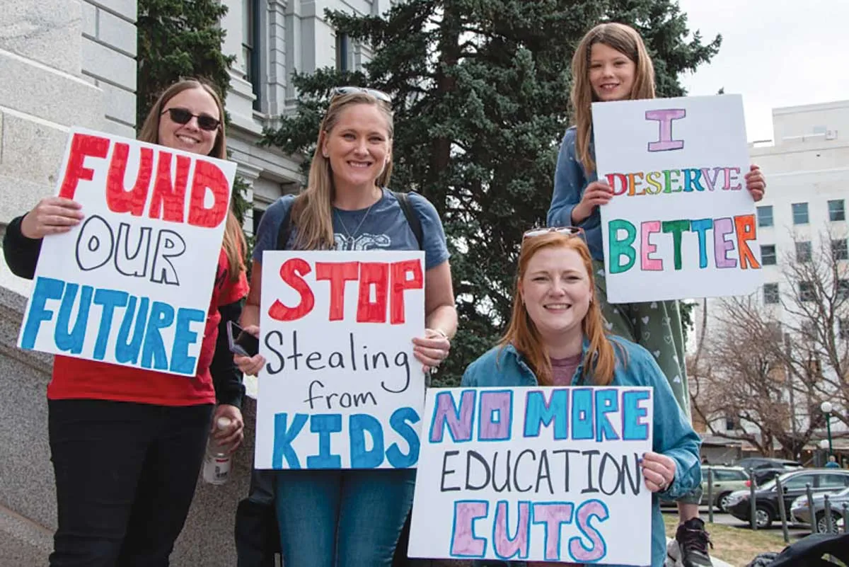 Four female protesters with various signs.