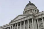 The dome and entrance of the Utah capitol against a grey sky.