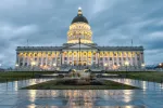 Utah's capitol building on a cloudy evening with wet pavement reflecting the building's lights. 