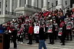 Group of people rally at the capitol. 