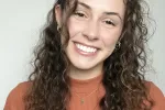 Picture of woman with curly brown hair smiling.