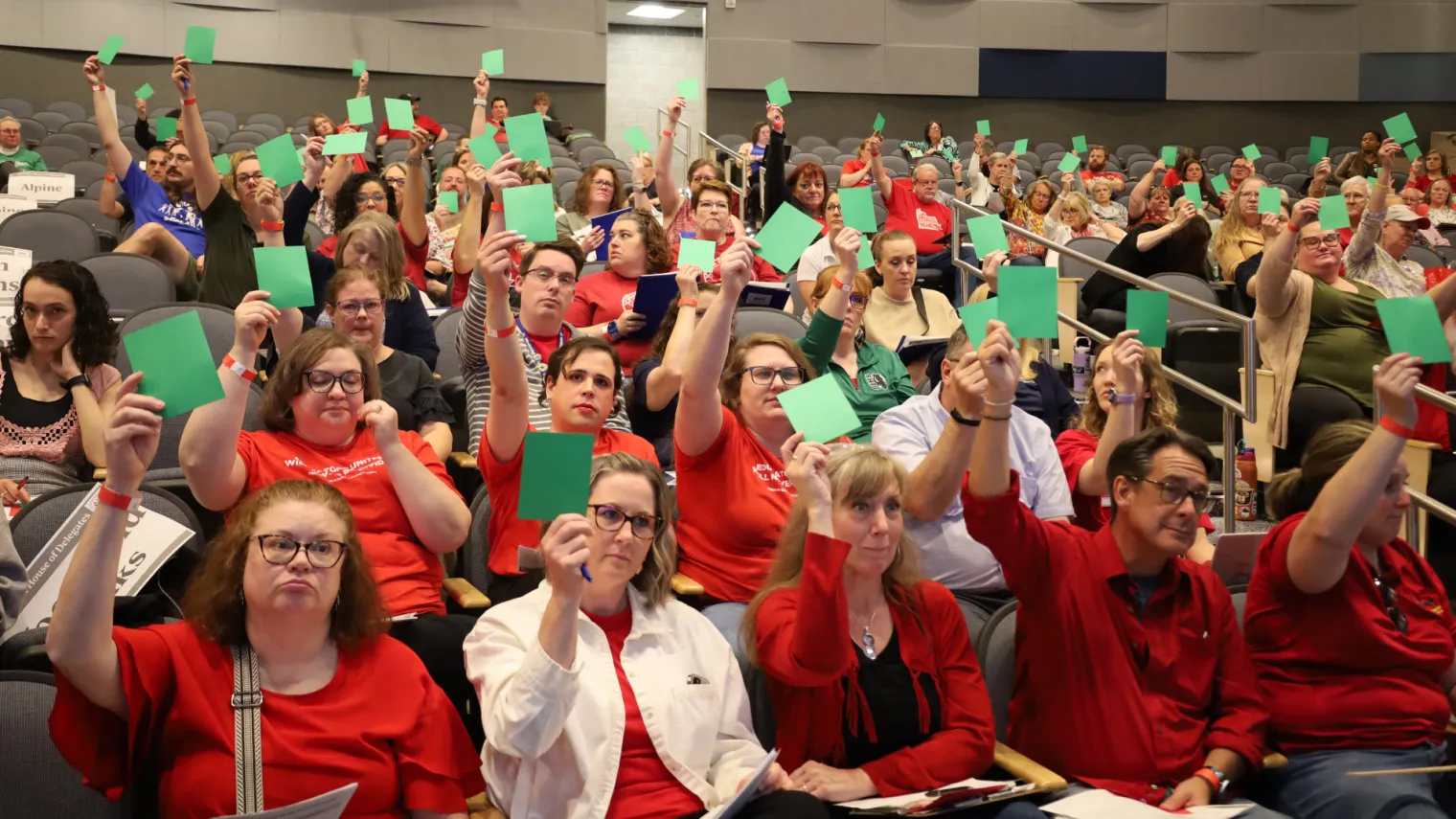 Group holding up green cards while voting at HOD.