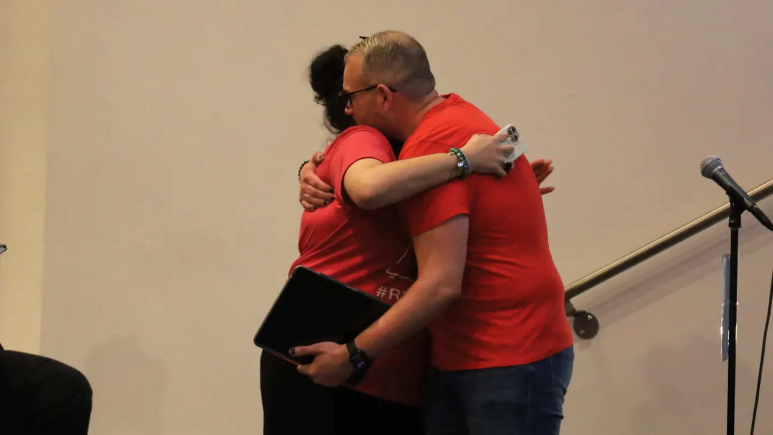 Two people hug wearing red.