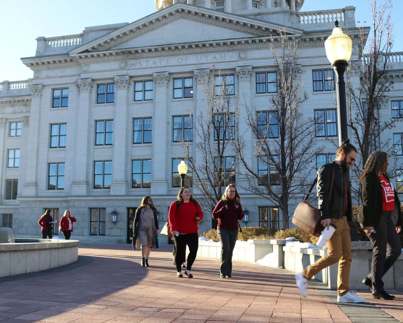 UEA members walking in front of the Utah state capitol building to advocate for educators an students on a sunny day.