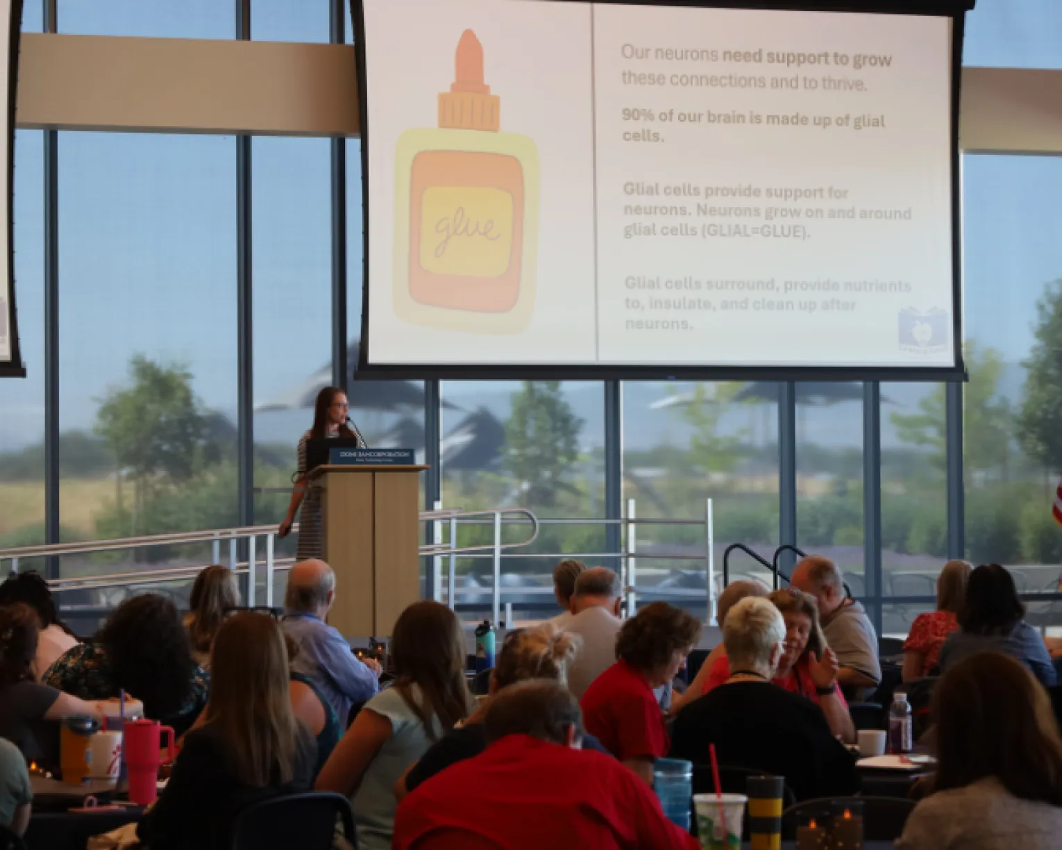 Woman speaking at podium to crowd