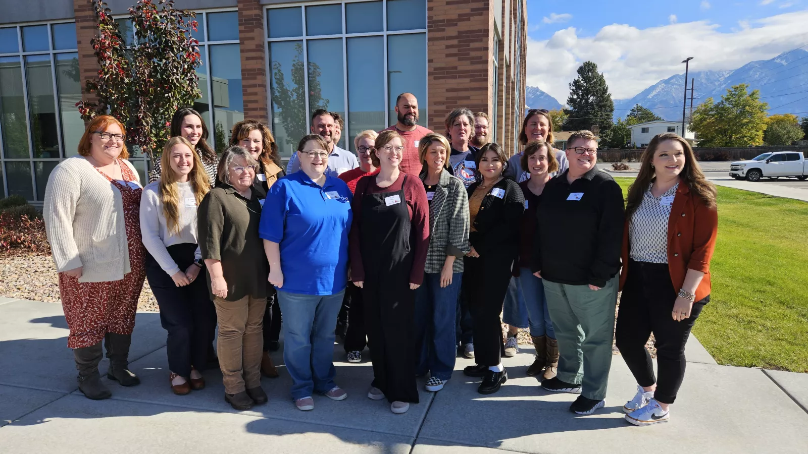 A group of educators standing outside smiling with a building in the background.