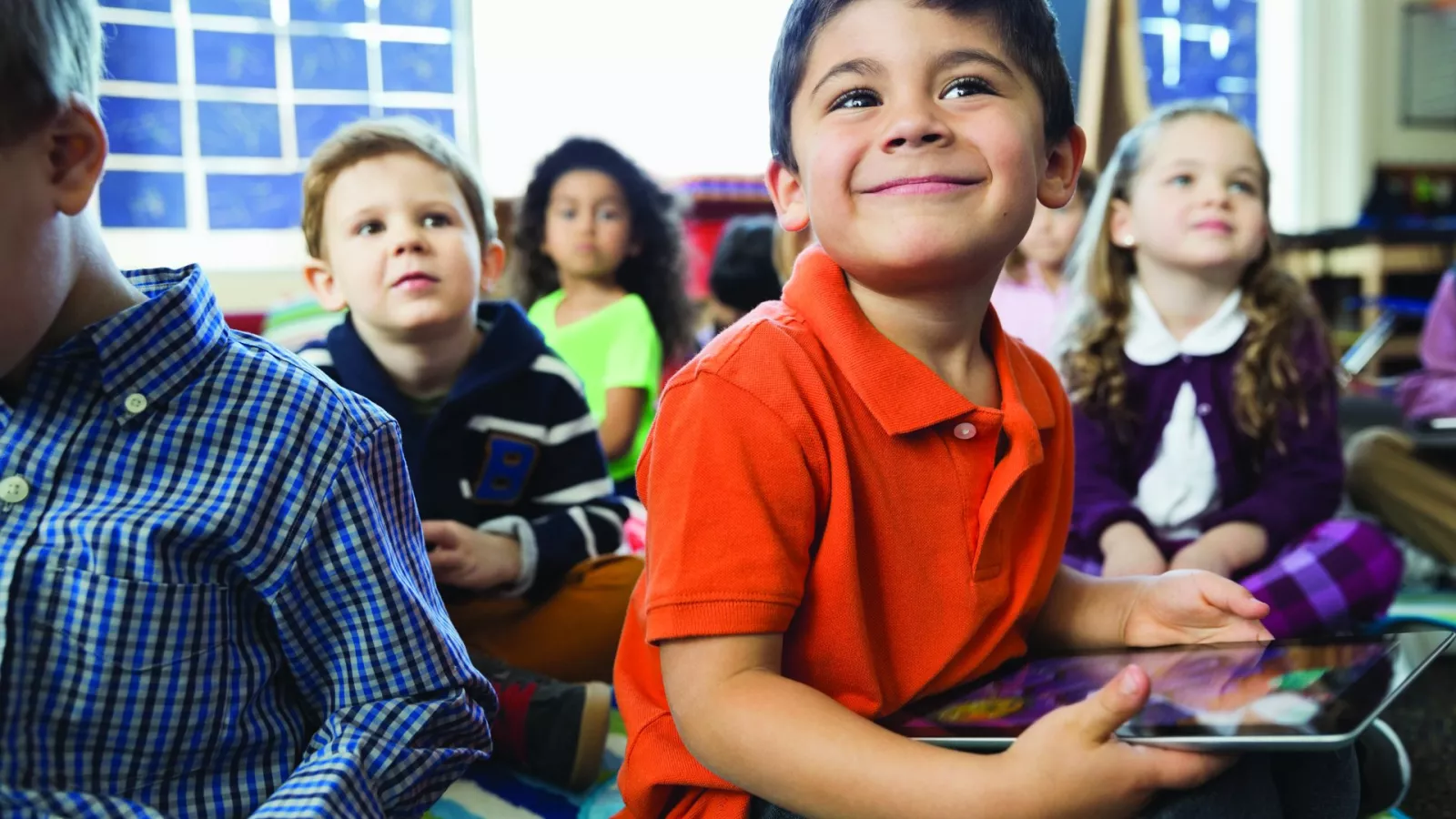 Smiling students are gathered for storytime