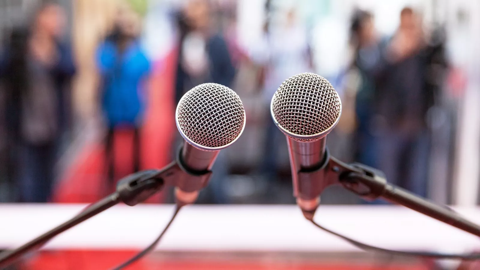 Two microphones at a stand with a blurred background.