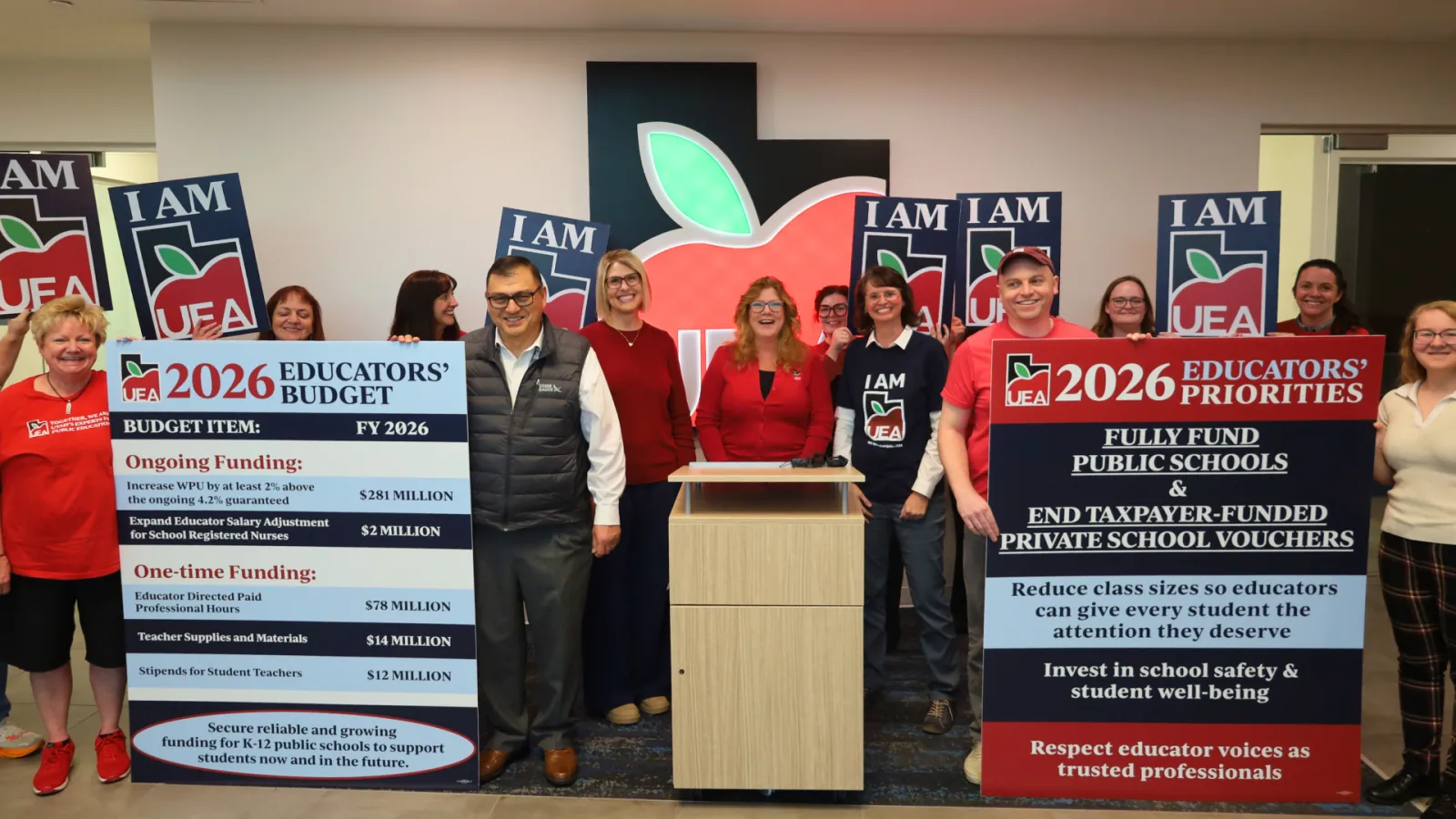 Group of educators holding signs.