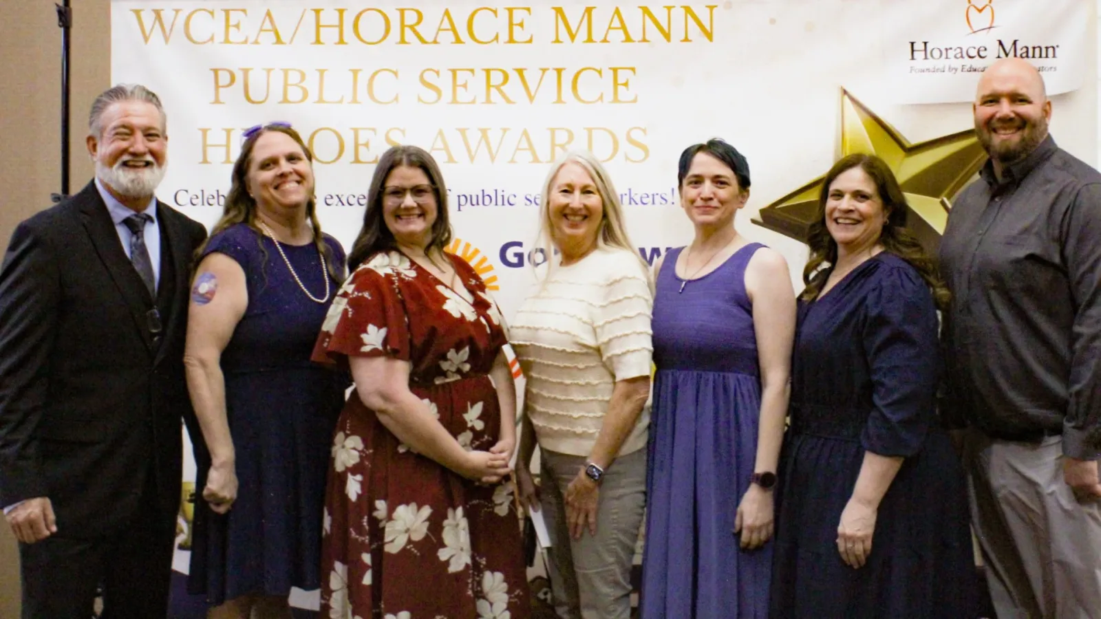 Seven educators smile at an award banquet