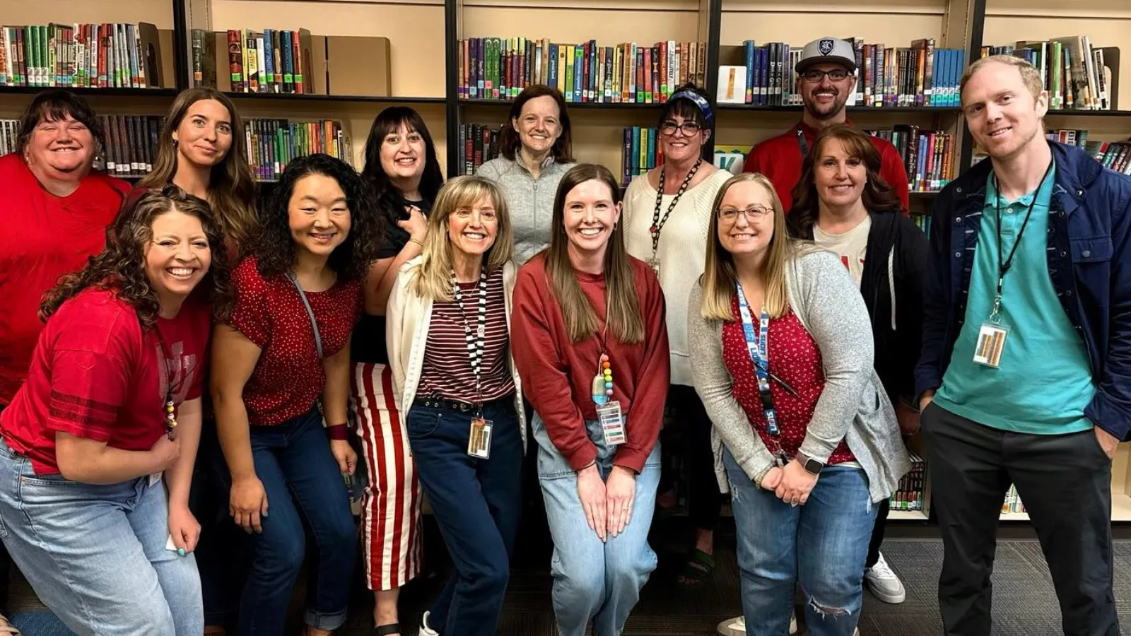 Group of UEA members smiling in a library. 