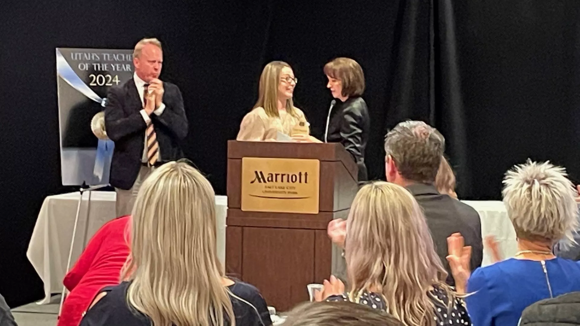 Carly Maloney thanks Syd Dixon during gala while audience applause.