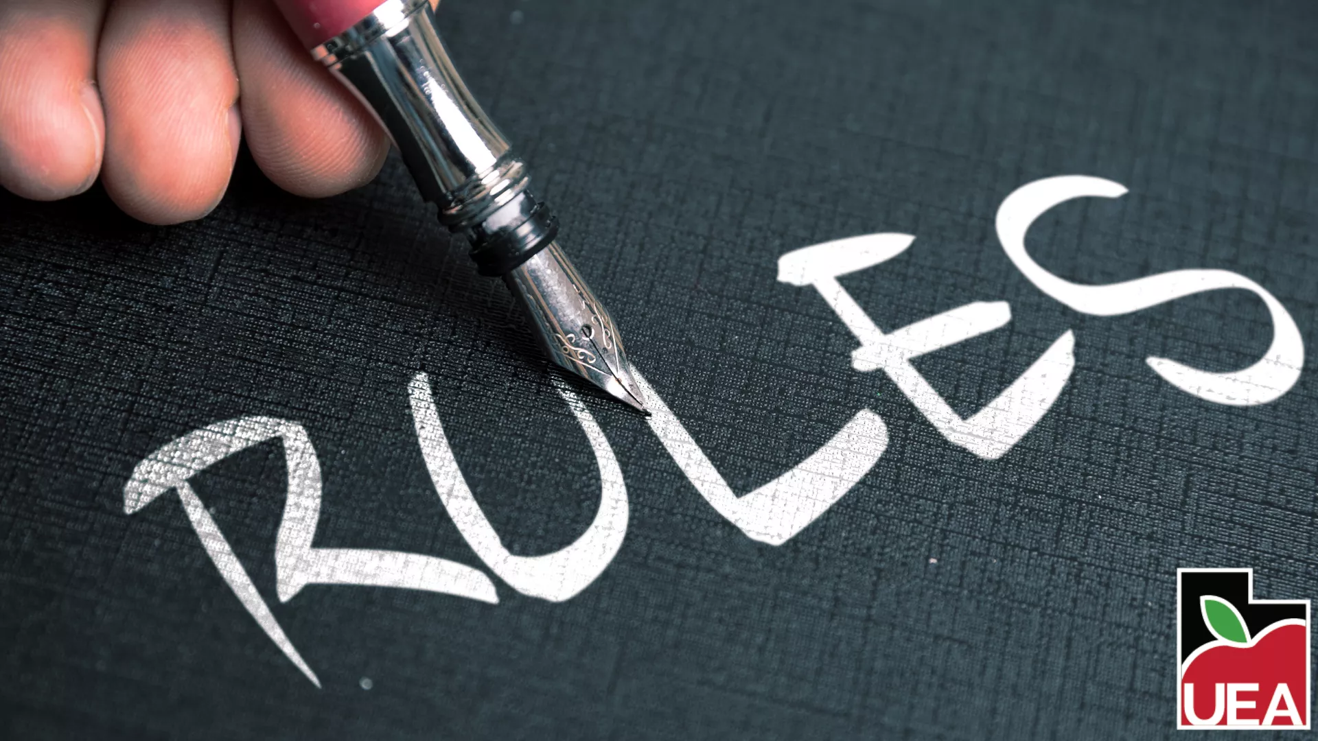 The word "rules" written on a chalkboard.