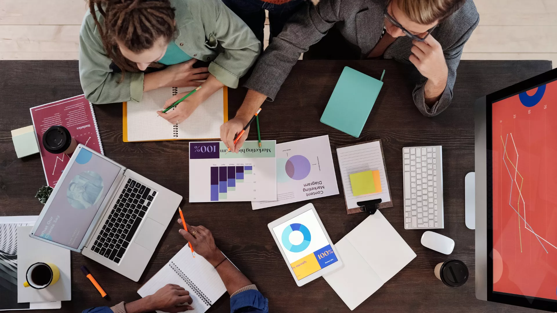 People sitting around a desk working. 