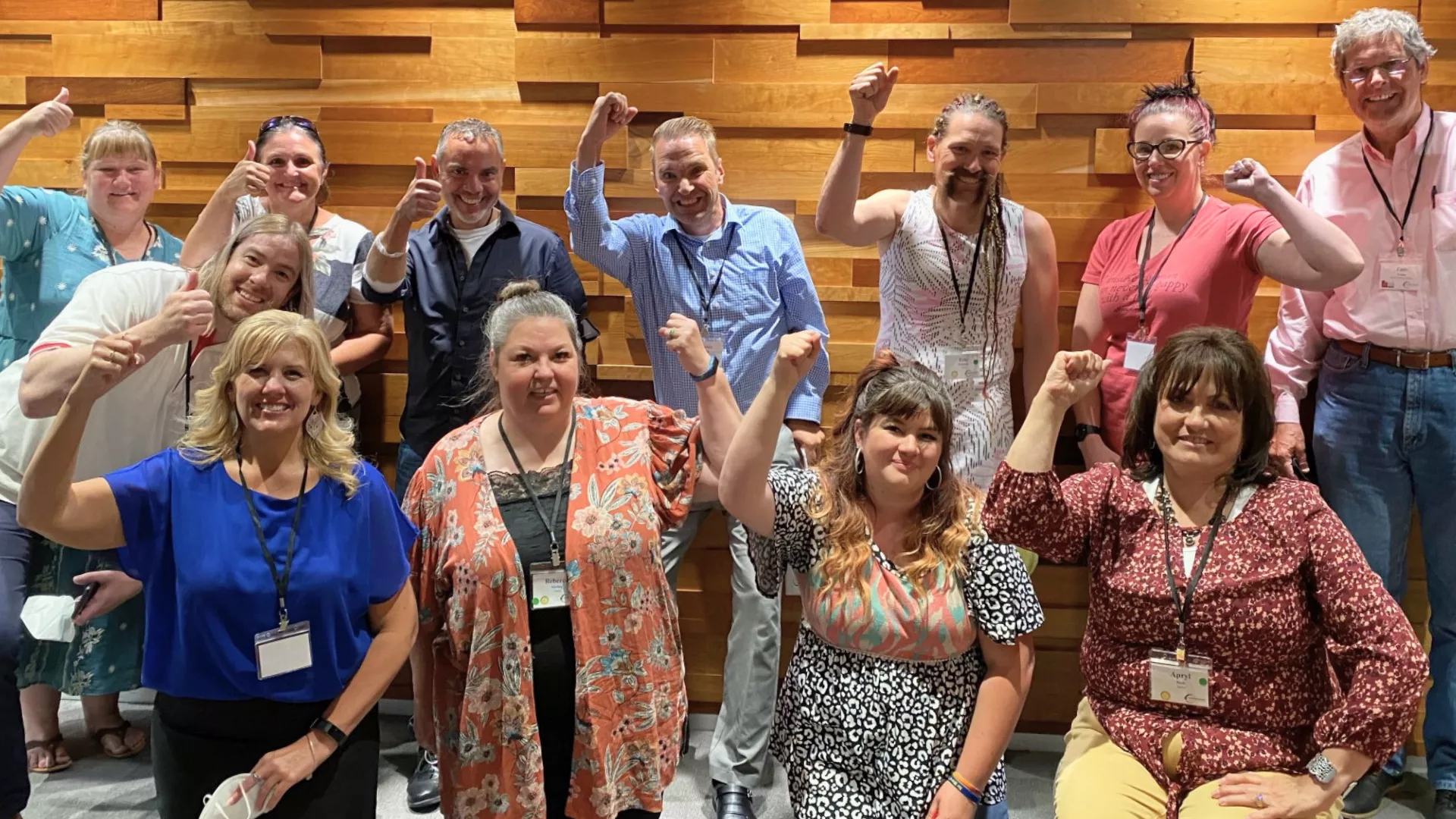 Eleven people with their fists up and smiling.