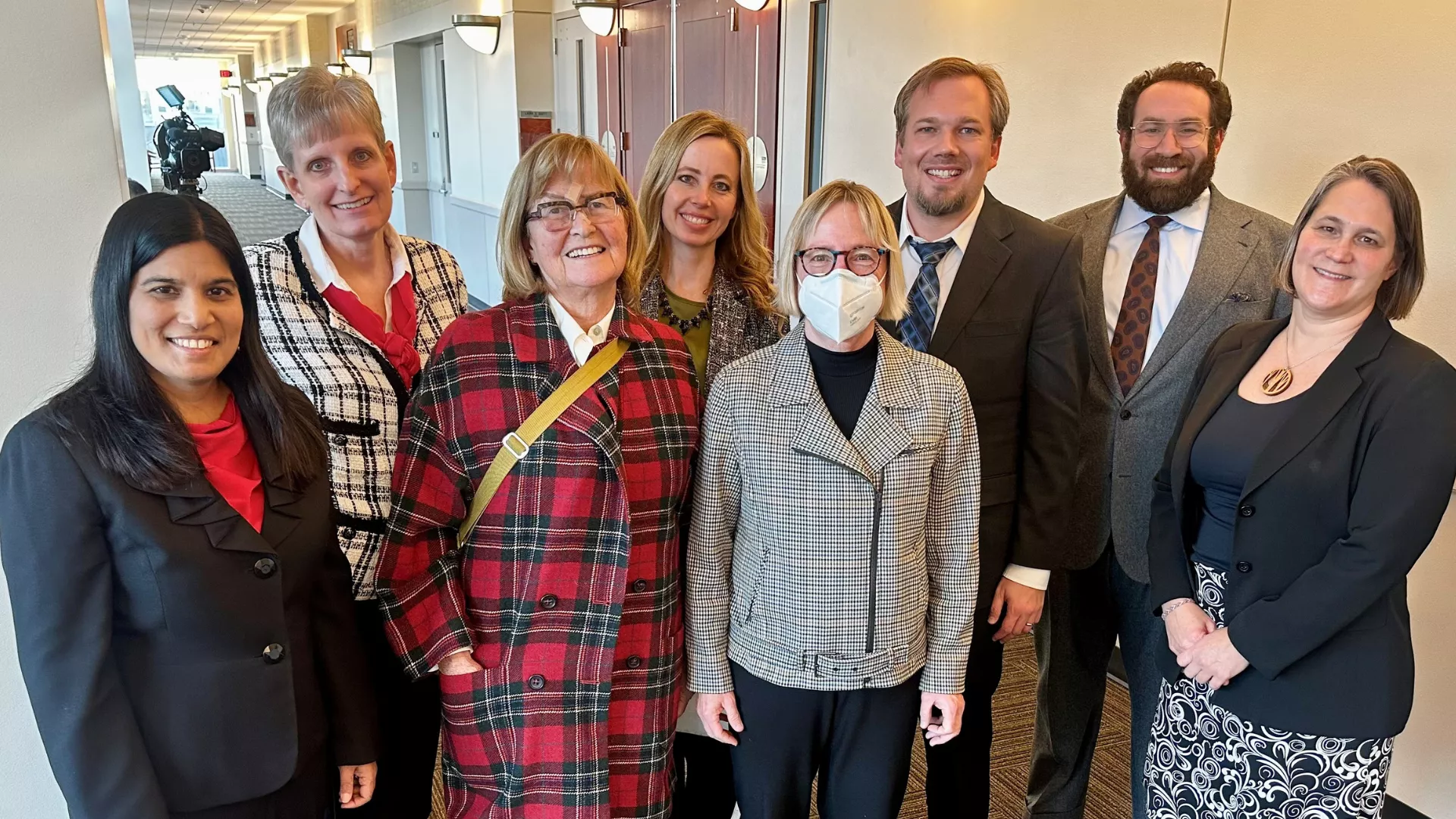 Attorneys and plaintiffs pose for picture outside courtroom.