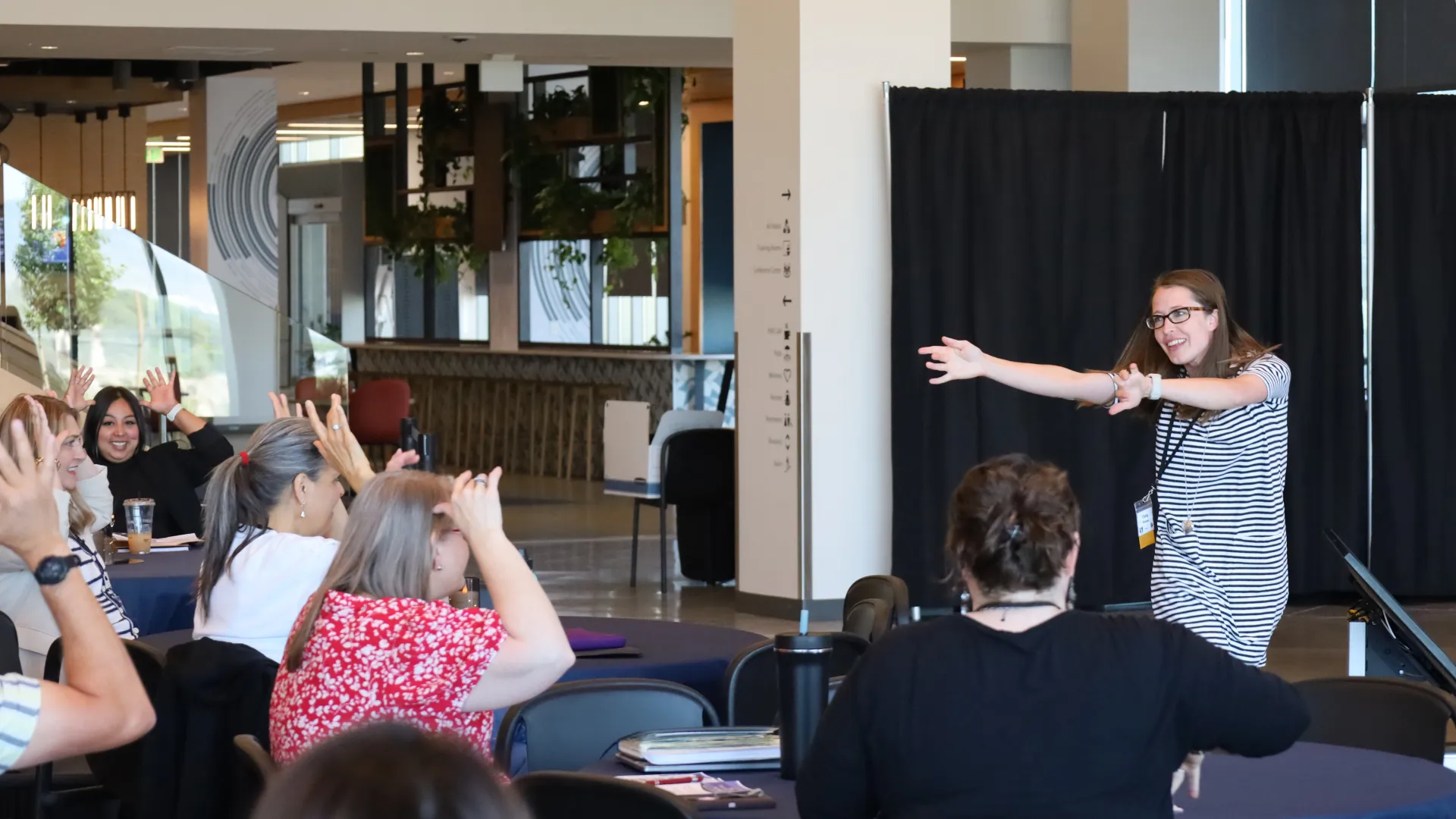 Woman stands in front of group of educators.