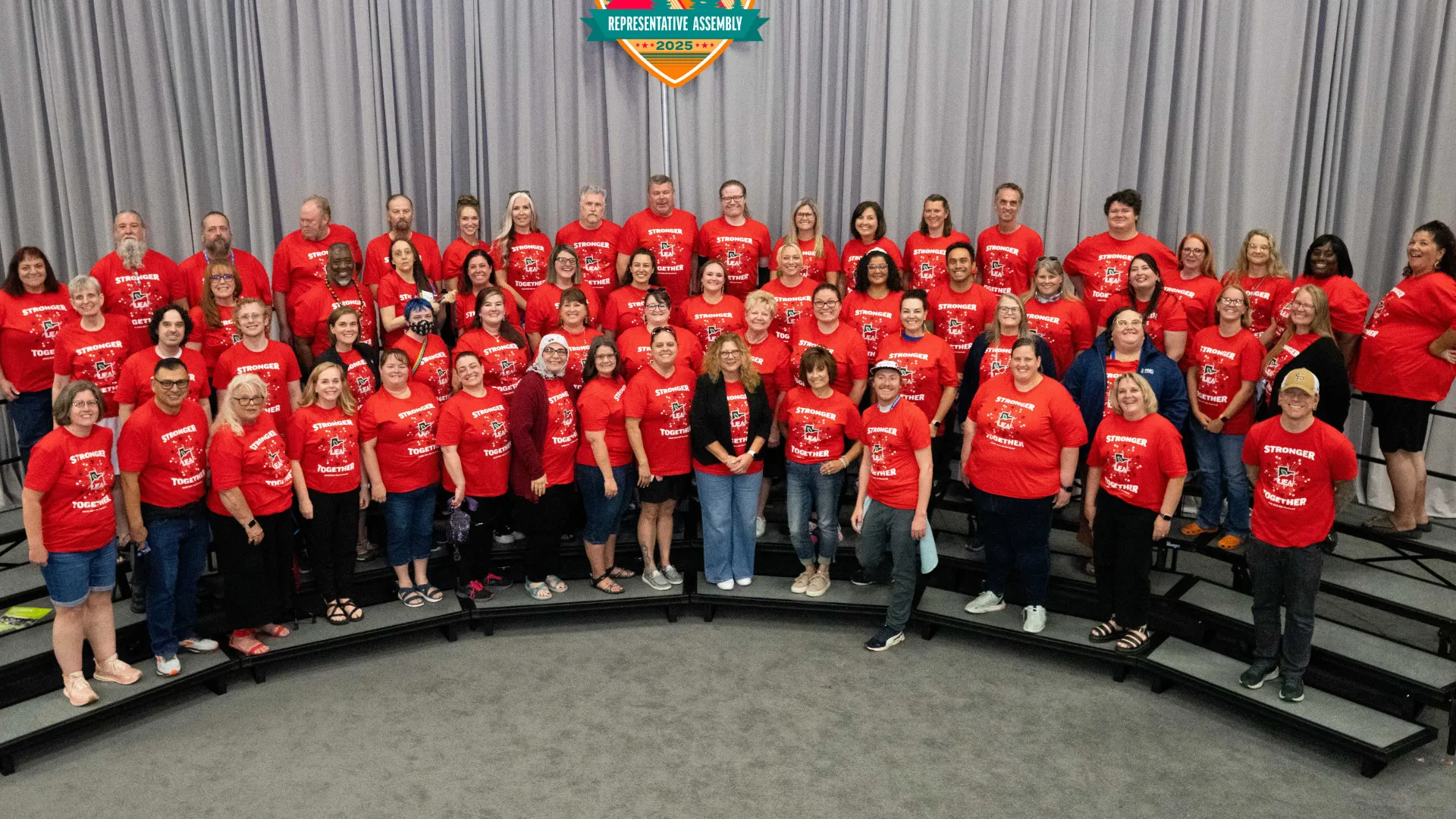 Group of educators wearing red smile at the camera. 