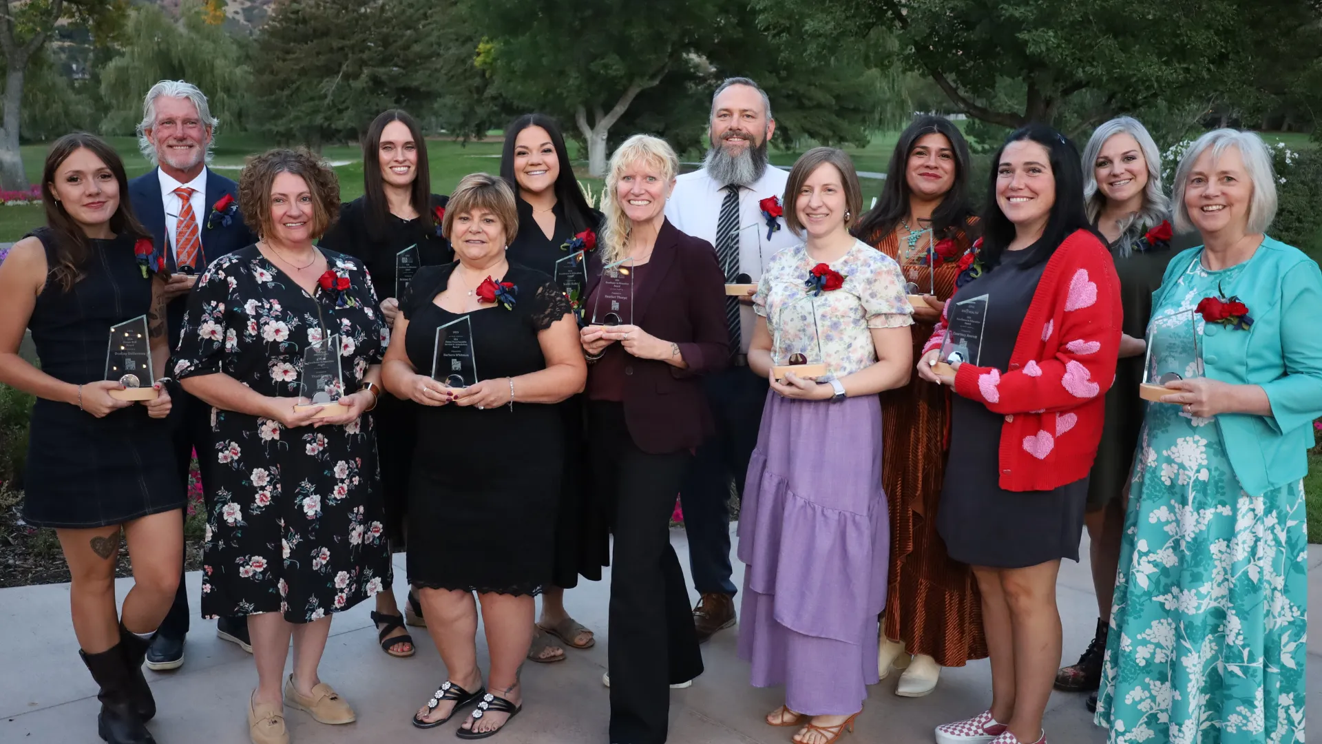 Ten people hold trophies. 