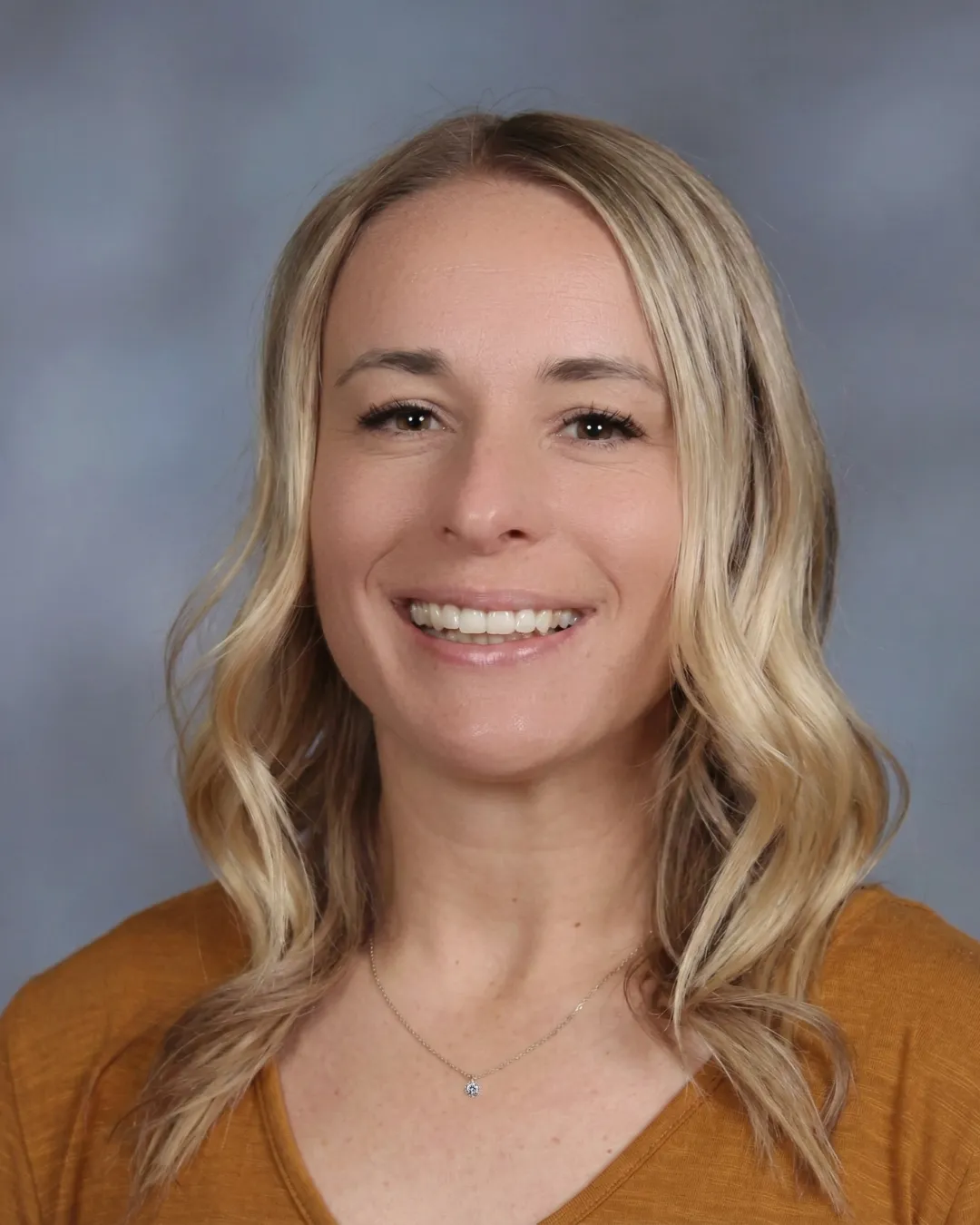 Woman smiling with blonde hair. 