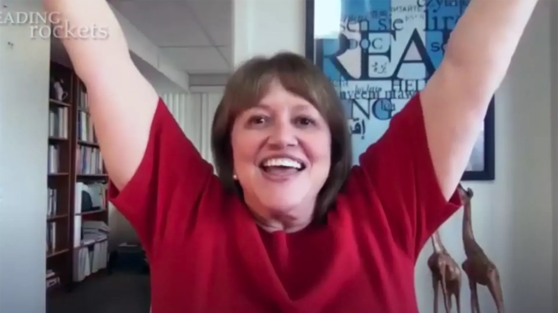 Linda Farrell demonstrates hand motions to go with teaching the letter Y to young students