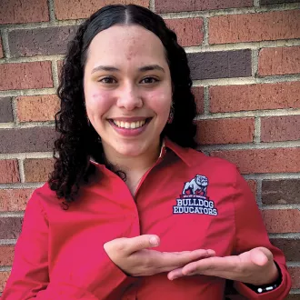 Adriana Perez standing in front of a brick wall