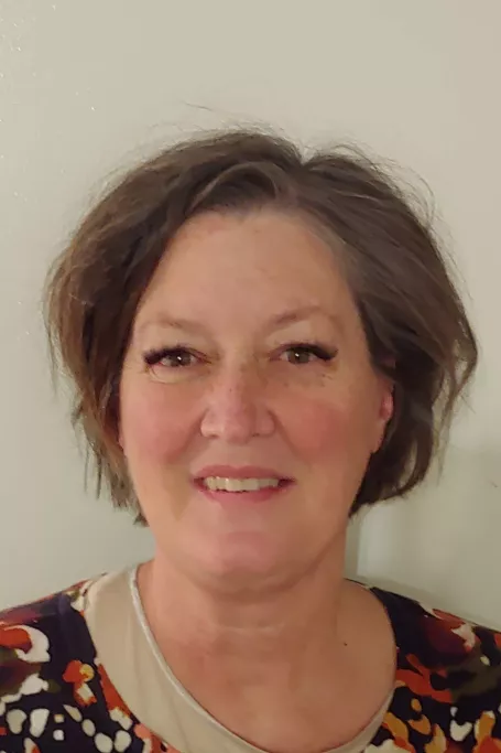 White woman with short hair smiling at the camera.