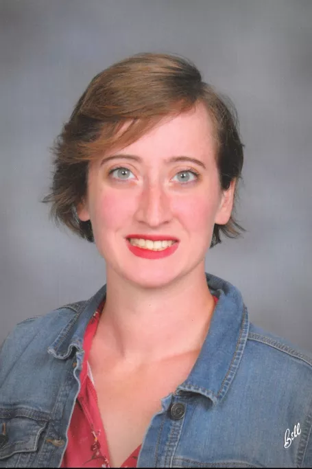 Woman wearing a denim jacket with short hair. 