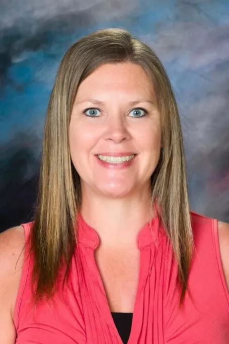 School photo of woman with pink tank top and blonde hair.