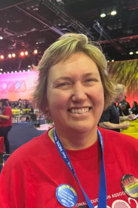 White woman with blonde hair in red shirt.
