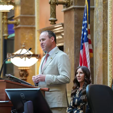 Speaker Mike Schultz stands at podium.