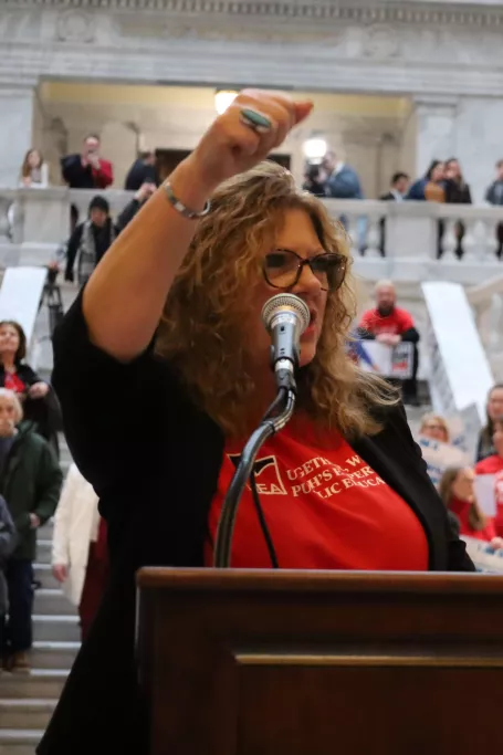President Pinkney standing at podium with fist up.