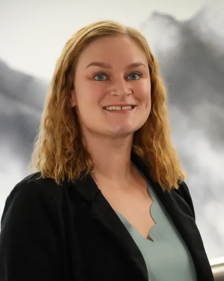 Woman smiling with dark suit jacket.