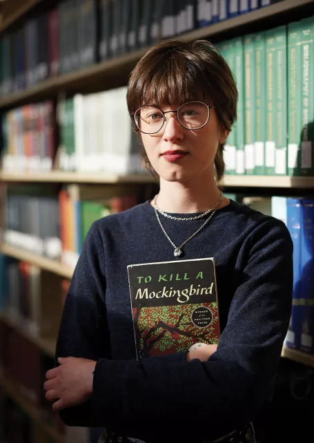 Alex Johnson stands in her college library