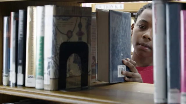 young boy in library stacks