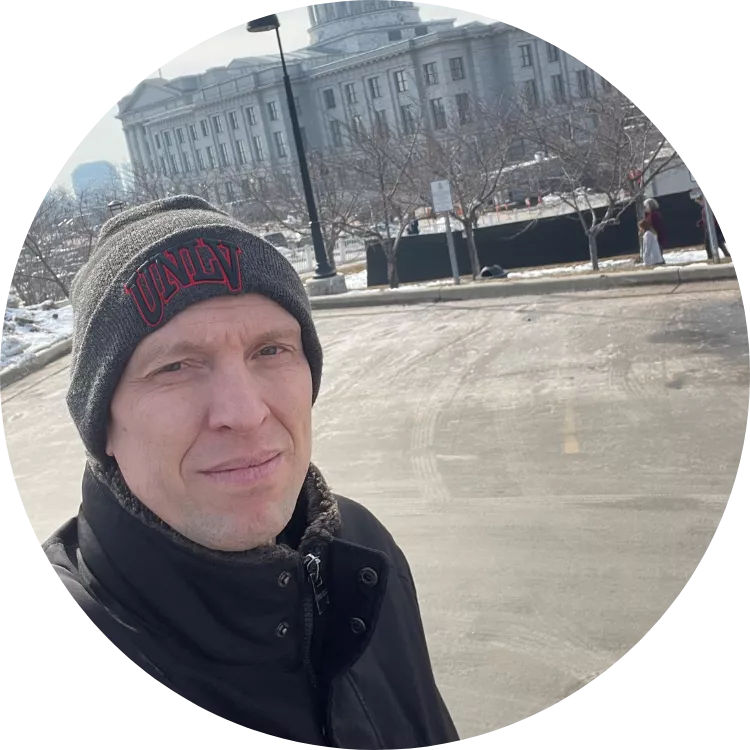 Man wearing grey hat outside Utah State capitol on cold day.