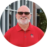 Man in red shirt smiles.