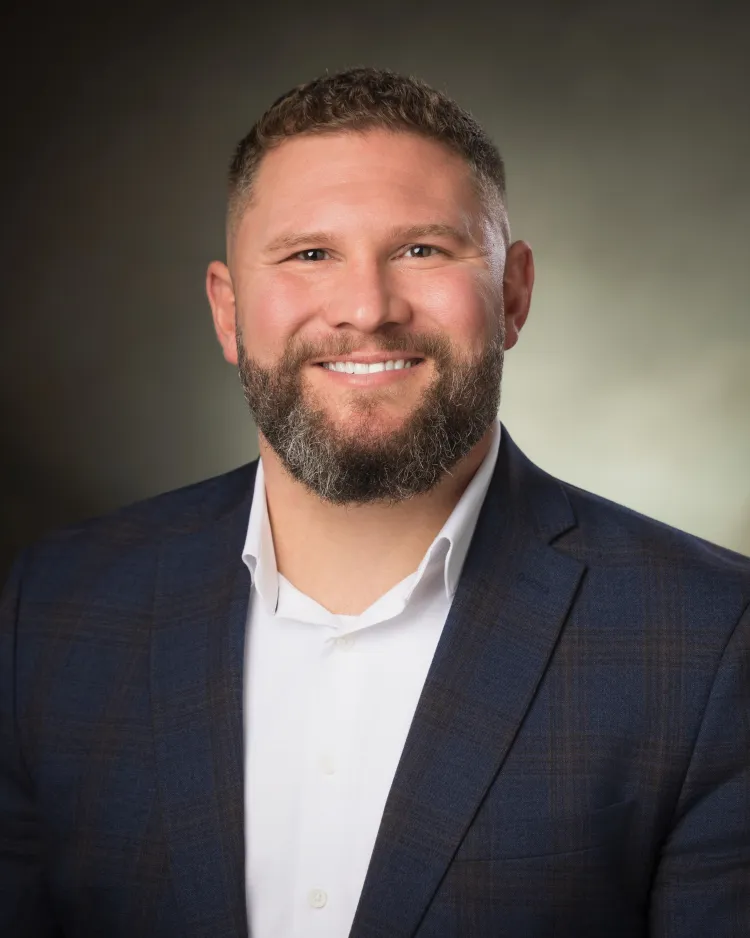 Greg Burrow in suit jacket smiling. 